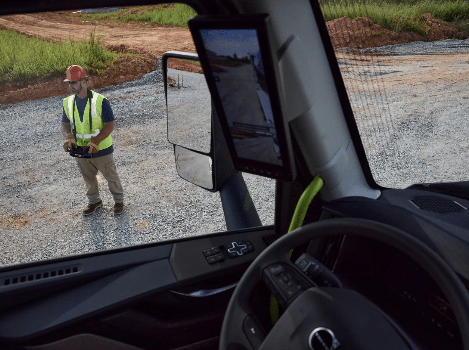 Operator in a hard hat standing beside a VNX, steering it with a Remote Steer wireless controller