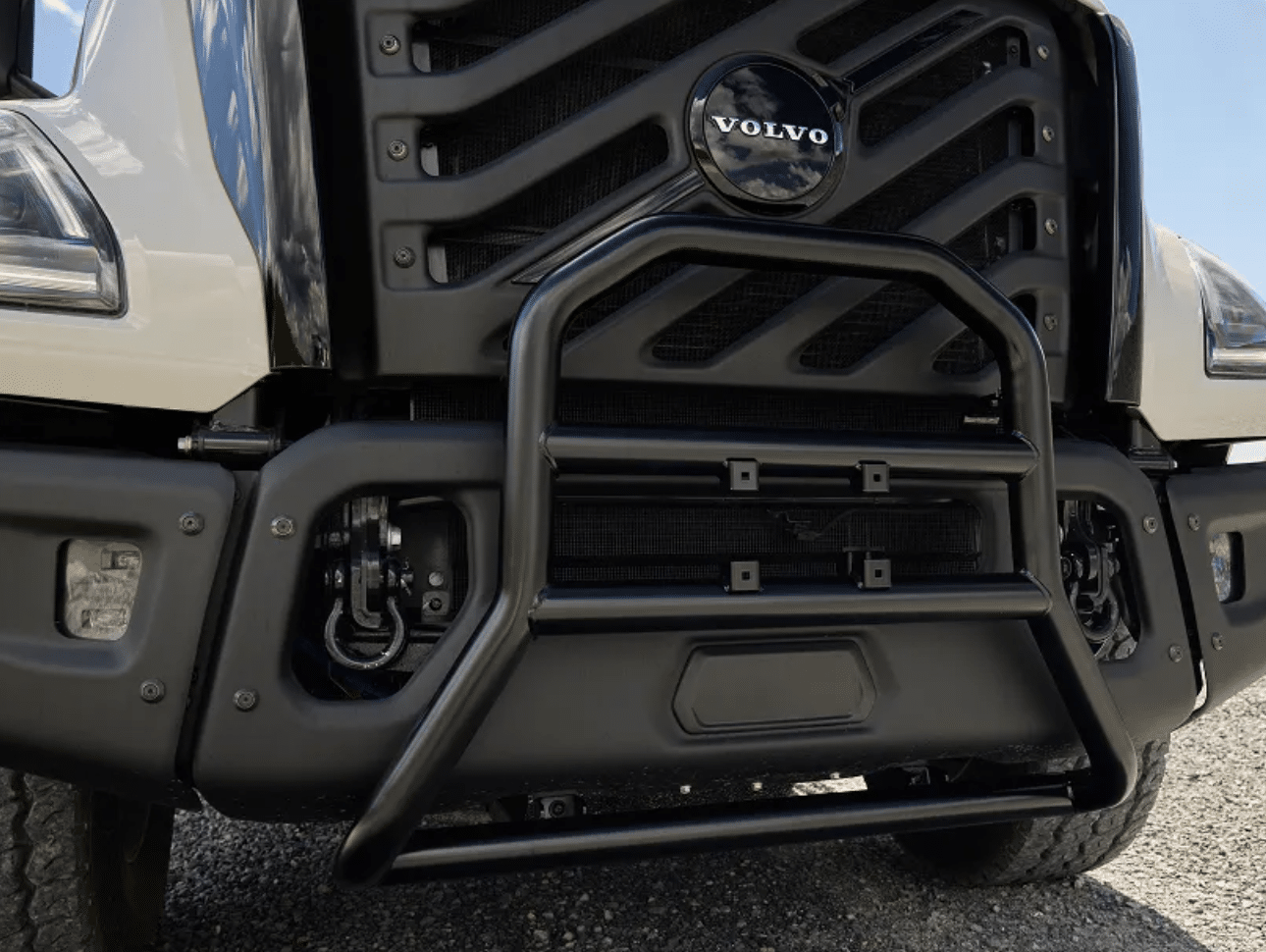 Close-up of the chrome three-piece bumper, tow hooks and steel-mesh grille on an orange VNX